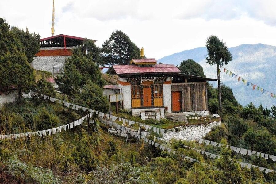 Monastery buildings and prayer flags above the valley