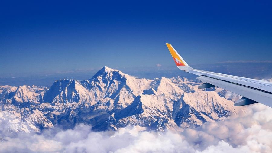 Aircraft wing above snow-capped Himalayan peaks