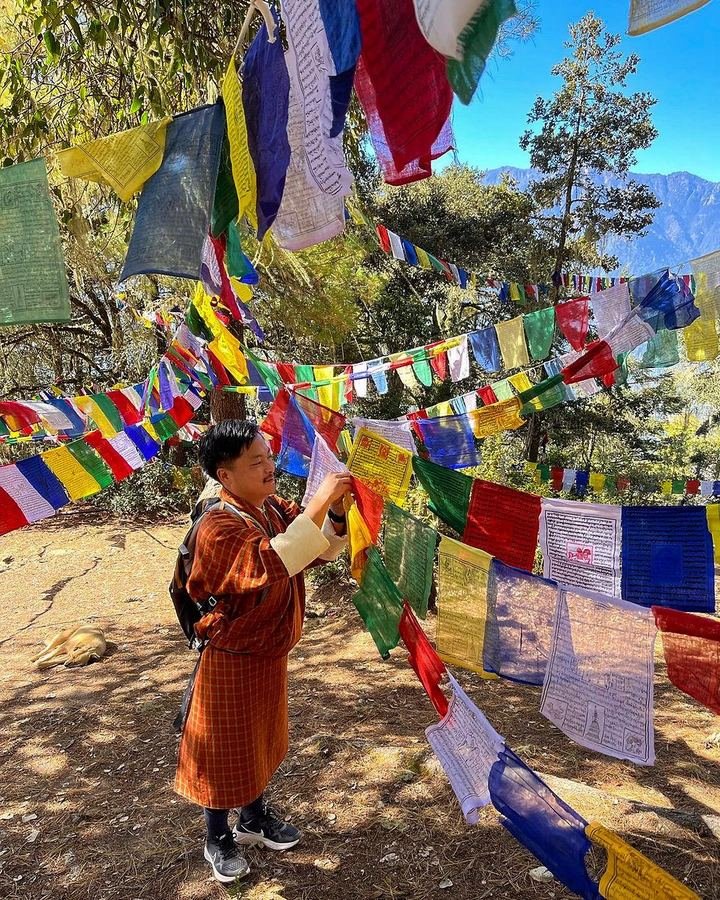 Monk among prayer flags on a hillside