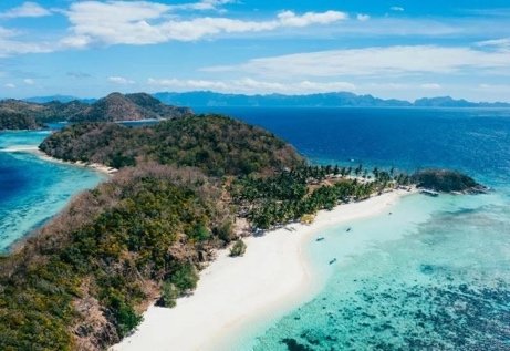 Aerial view of a white sand island beach and turquoise water near Coron