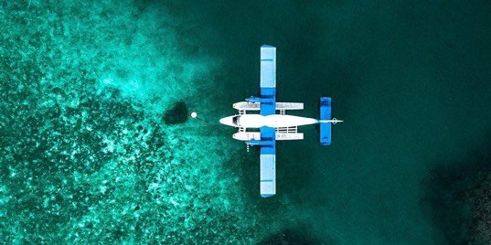 Overhead view of a seaplane above a shallow coral reef