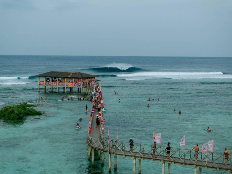 The Cloud 9 boardwalk and viewing tower with a clean wave breaking beyond the reef